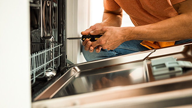 primo pinao mani con cacciavite davanti a lavastoviglie aperta
