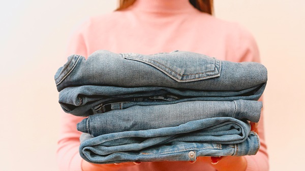 jeans piegati in mano