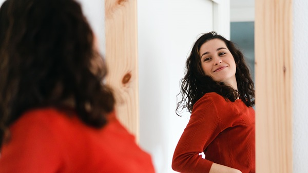 ragazza si guarda allo specchio sorride