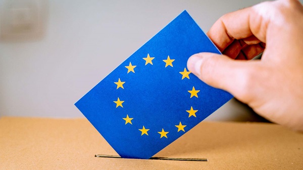 mano inserisce foglio con bandiera europea in un'urna